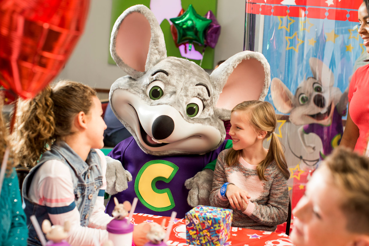 Chuck E. visiting with kids at table