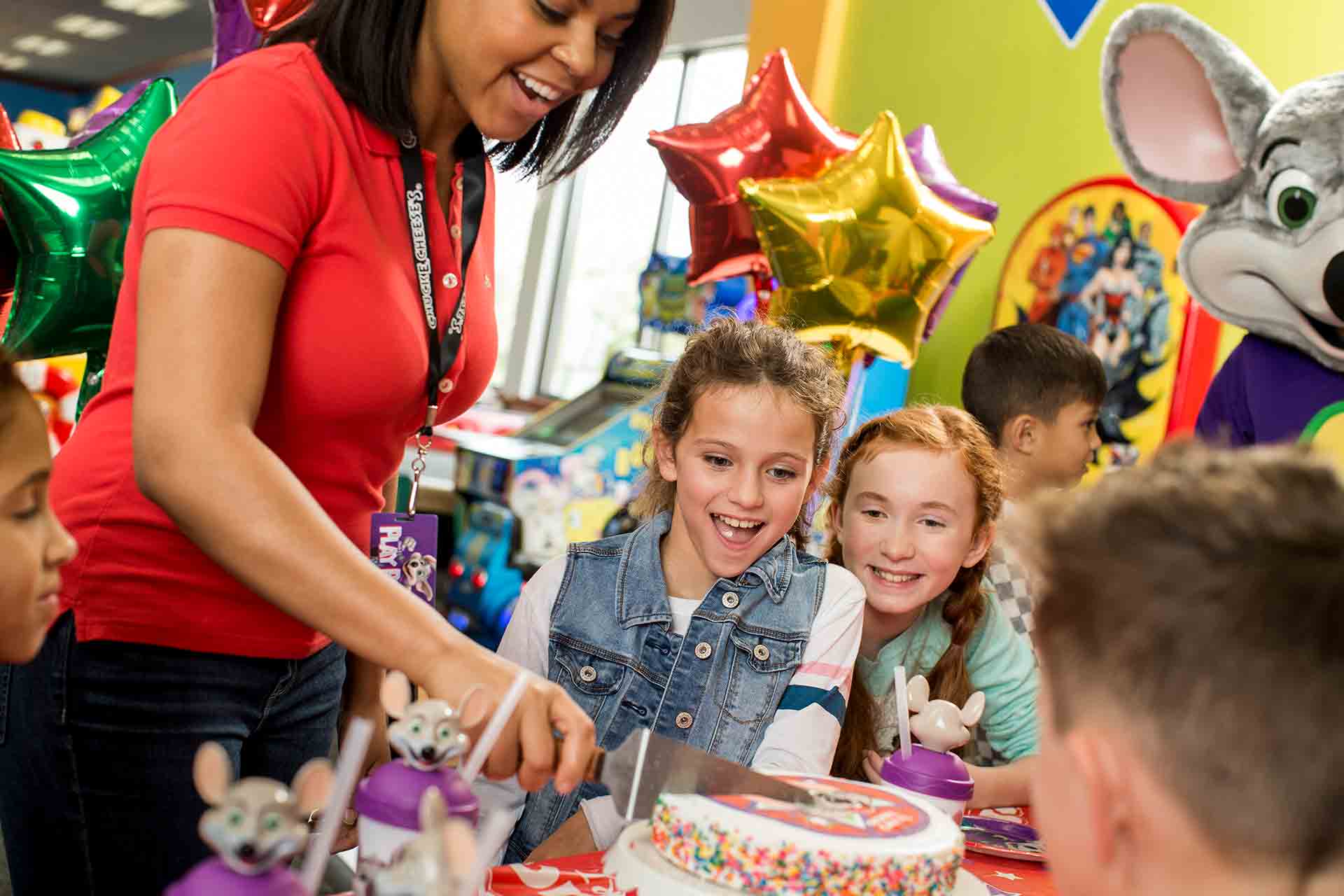 Employee cutting cake for kids