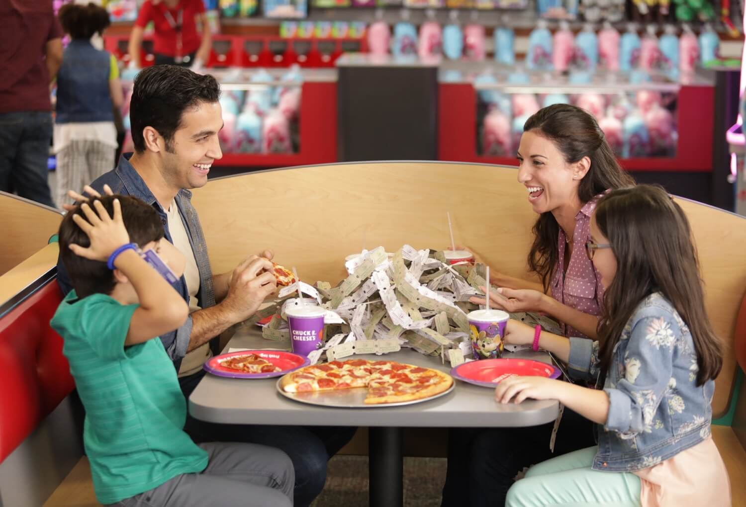 Family eating dinner with pizza and tickets on table