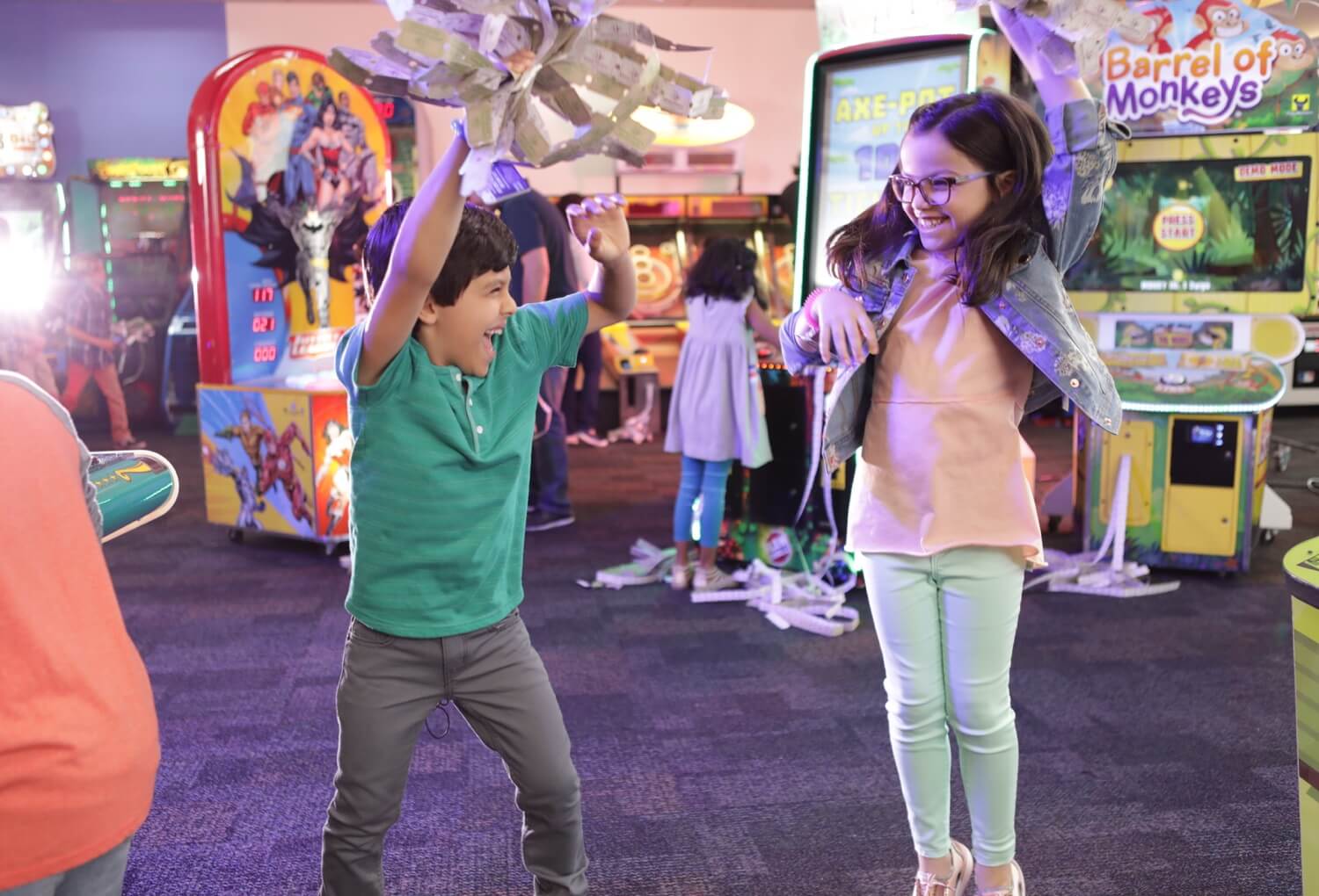 Two kids dancing while holding tickets