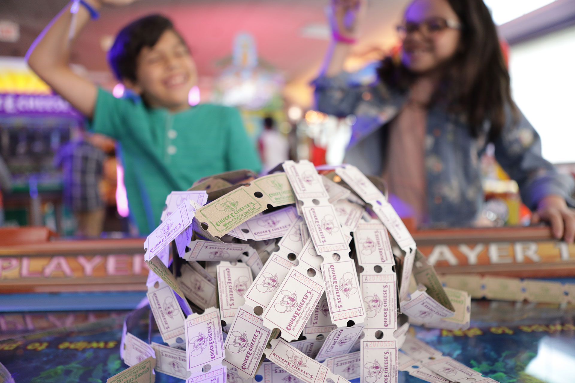 Two kids cheering behind pile of tickets
